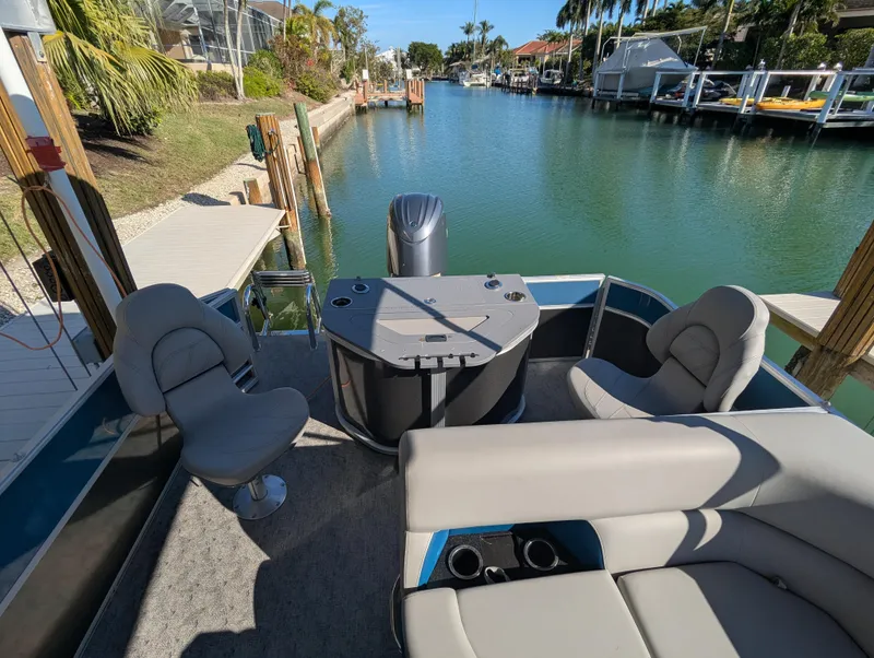 Slide: The Image of 2024 Trifecta 22TRFC LE 2.75 pontoon boat docked on a scenic canal. - 27