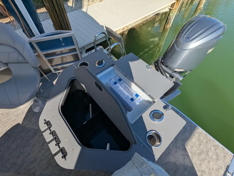 Slide: The Image of 2024 Trifecta 22TRFC LE 2.75 boat with open storage and motor, docked by water. - 31