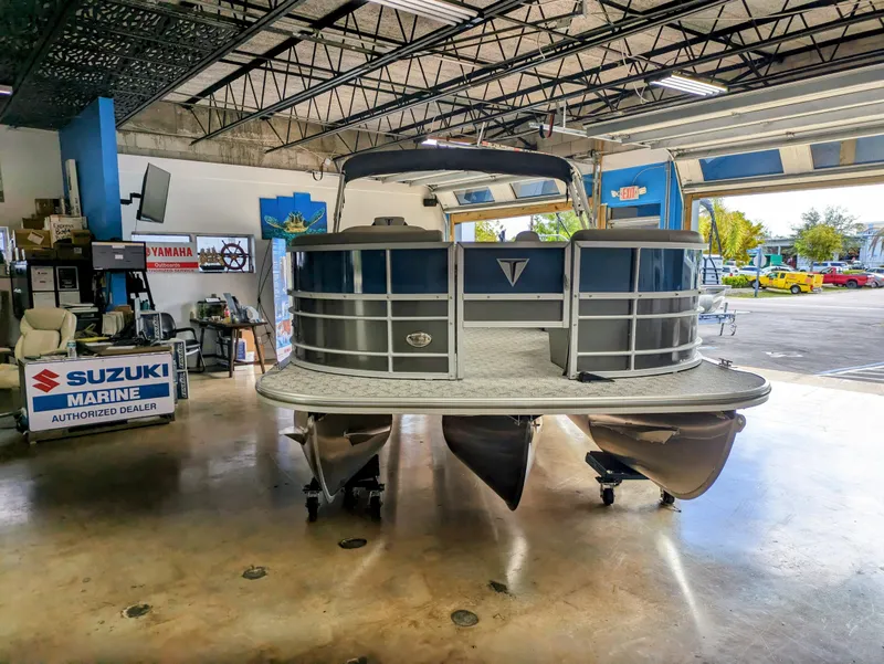 Slide: The Image of 2024 Trifecta 22TRFC LE 2.75 pontoon boat displayed in a Suzuki Marine dealership. - 4