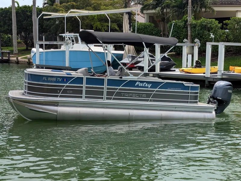 Slide: The Image of 2024 Trifecta 22TRFC LE 2.75 pontoon boat docked on a calm waterway. - 5