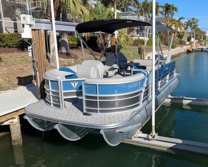 Slide: The Image of 2024 Trifecta 22TRFC LE 2.75 pontoon boat docked in a sunny marina. - 6