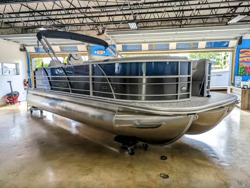 Slide: The Image of 2024 Trifecta 22TRFC LE 2.75 pontoon boat in a showroom, showcasing sleek design. - 8
