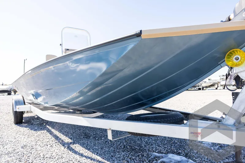 Slide: The Image of 2025 G3 Bay 21 GX boat on trailer, side view, parked on gravel. - 10
