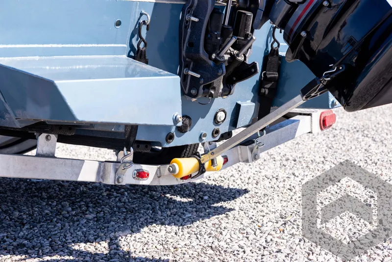Slide: The Image of 2025 G3 Bay 21 GX boat trailer hitch and motor detail on gravel surface. - 20
