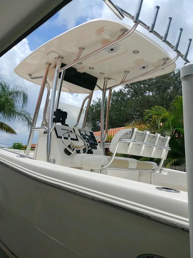 Slide: The Image of 2020 Bulls Bay 230 CC boat with T-top and console, surrounded by tropical foliage. - 14