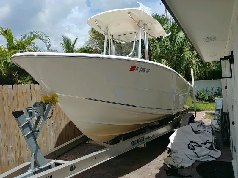 Slide: The Image of 2020 Bulls Bay 230 CC boat on trailer, parked outdoors near palm trees. - 2
