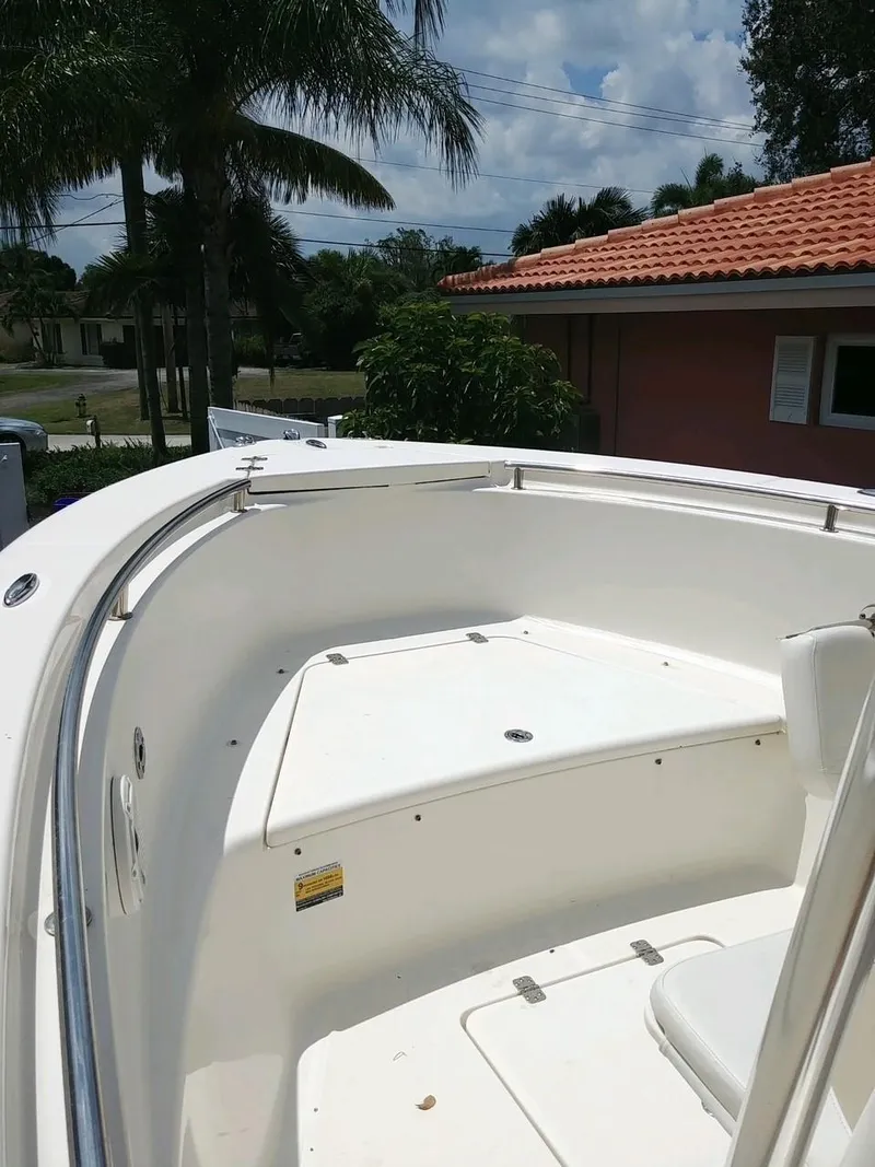 Slide: The Image of 2020 Bulls Bay 230 CC boat, white deck, outdoor setting, palm trees in background. - 6