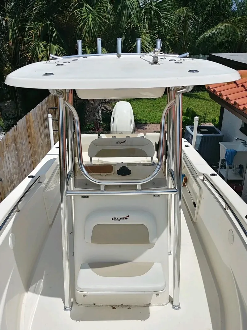 Slide: The Image of 2020 Bulls Bay 230 CC boat with T-top, docked near palm trees. - 7