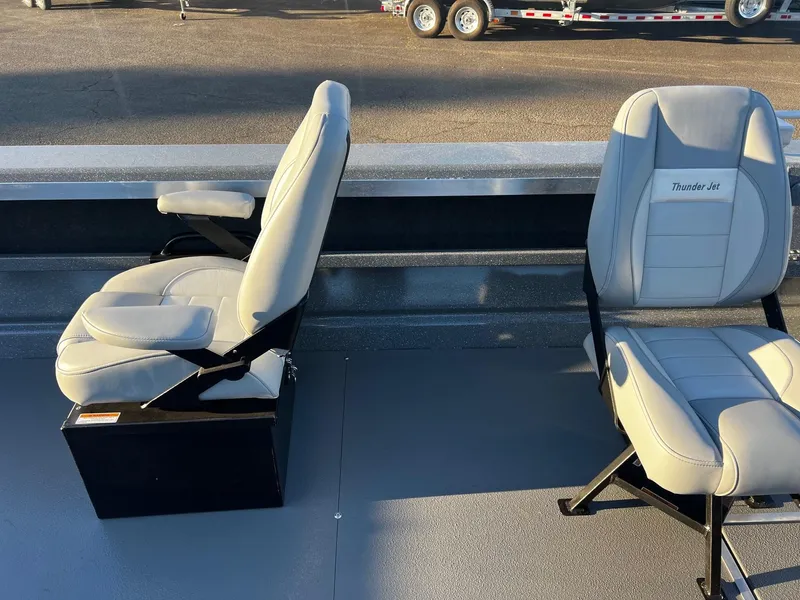 Slide: The Image of 2025 Thunder Jet 209 Rush OT boat seats, gray upholstery, outdoor setting. - 18