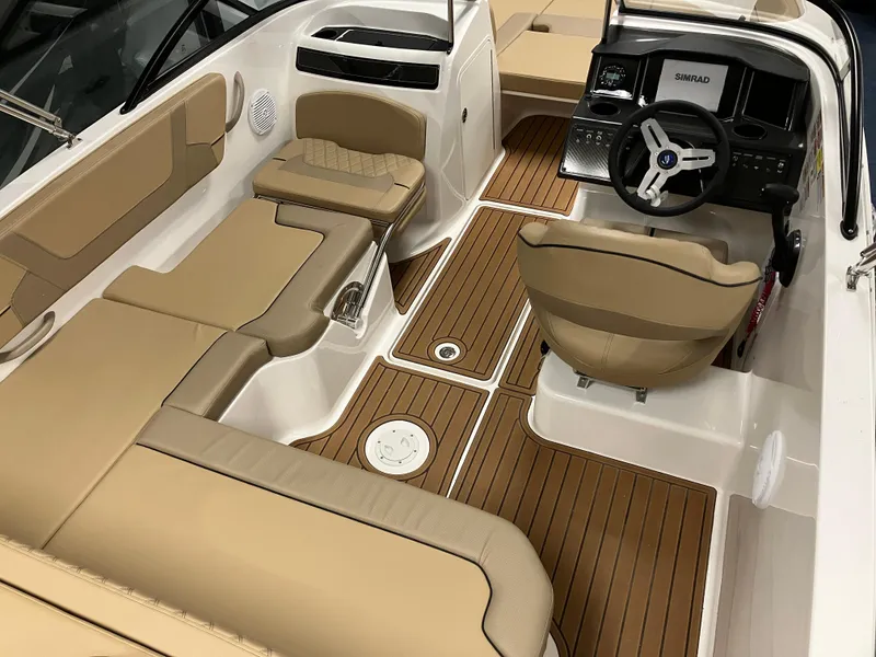 Slide: The Image of 2024 Bayliner VR5 Bowrider OB interior with tan seating and wood-style flooring. - 10