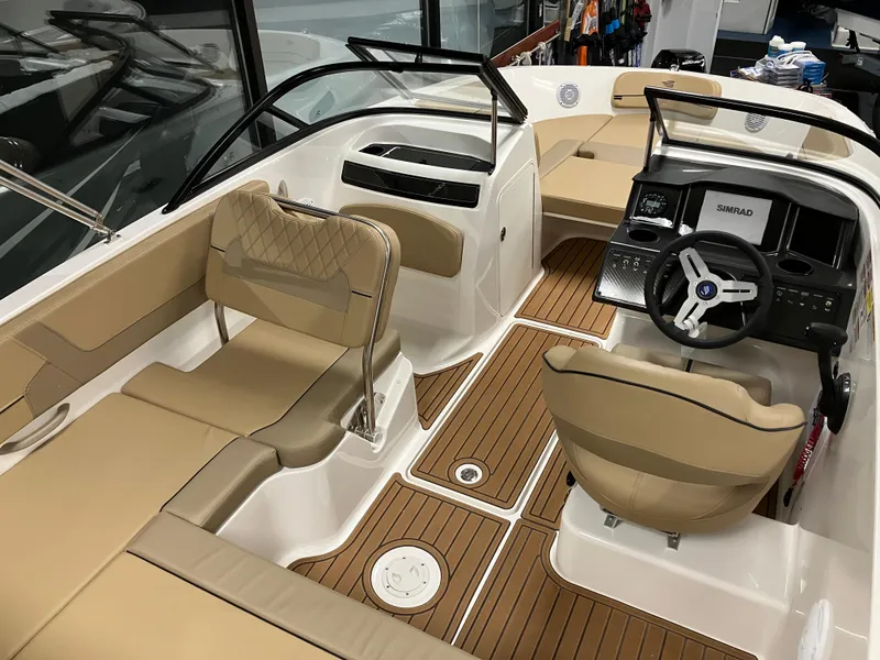 Slide: The Image of 2024 Bayliner VR5 Bowrider OB interior with tan seating and wood-style flooring. - 11