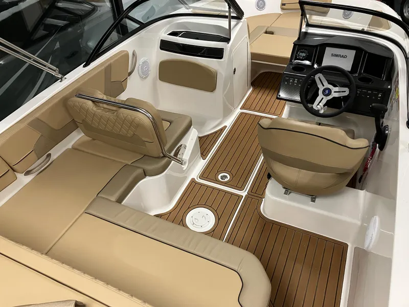 Slide: The Image of 2024 Bayliner VR5 Bowrider OB interior with tan seating and wood-style flooring. - 12