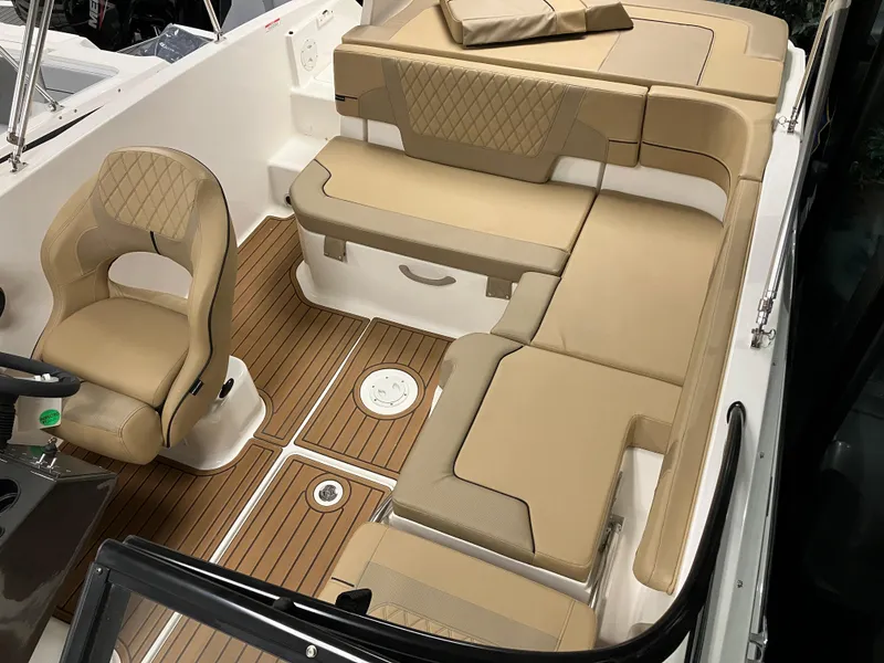 Slide: The Image of 2024 Bayliner VR5 Bowrider OB interior with tan seating and wood-style flooring. - 5