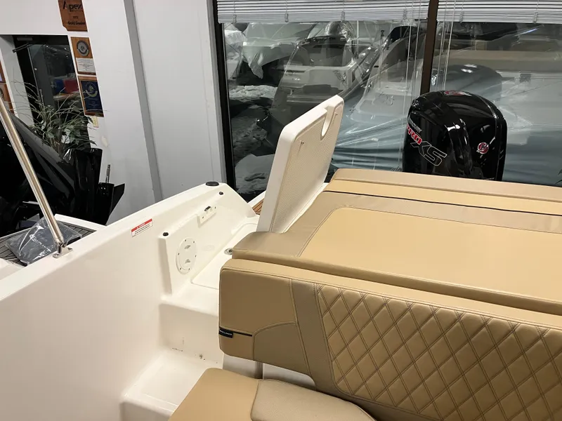 Slide: The Image of 2024 Bayliner VR5 Bowrider OB interior with beige seating and outboard motor. - 8
