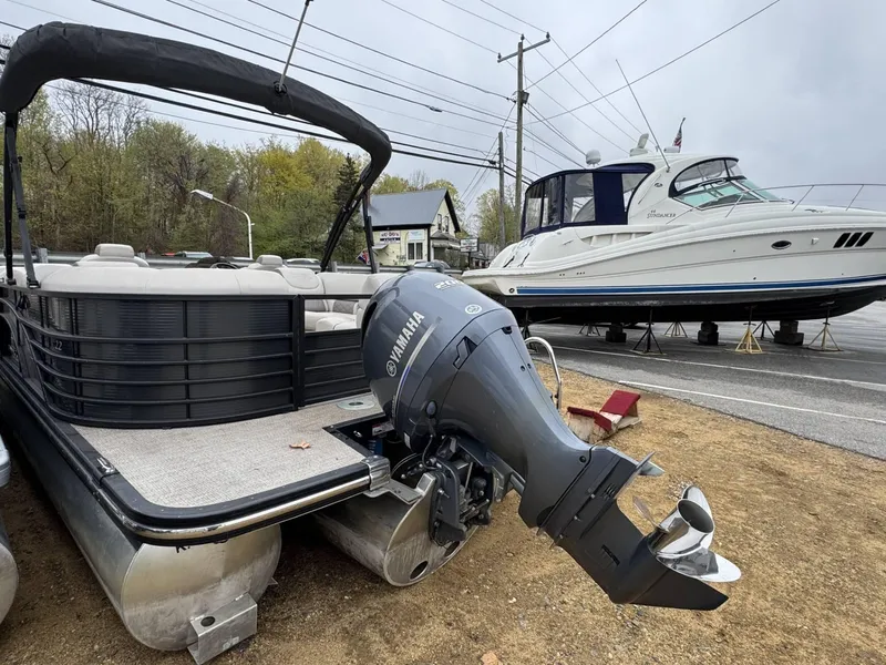 Slide: The Image of 2017 Bennington 226 GSR pontoon boat with Yamaha outboard motor, parked near a larger yacht. - 3