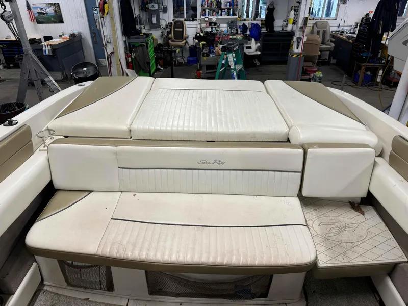 Slide: The Image of 2007 Sea Ray 230 Select boat interior with white cushioned seating in a workshop setting. - 9