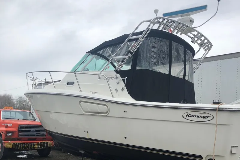 Slide: The Image of 2000 Rampage 30 Express boat with black canopy, docked near an orange truck. - 3