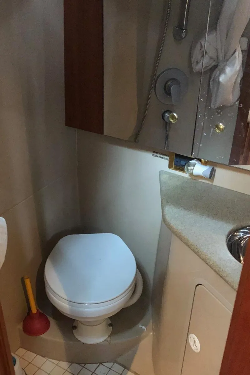 Slide: The Image of 2000 Rampage 30 Express boat bathroom with toilet, sink, and shower. - 8