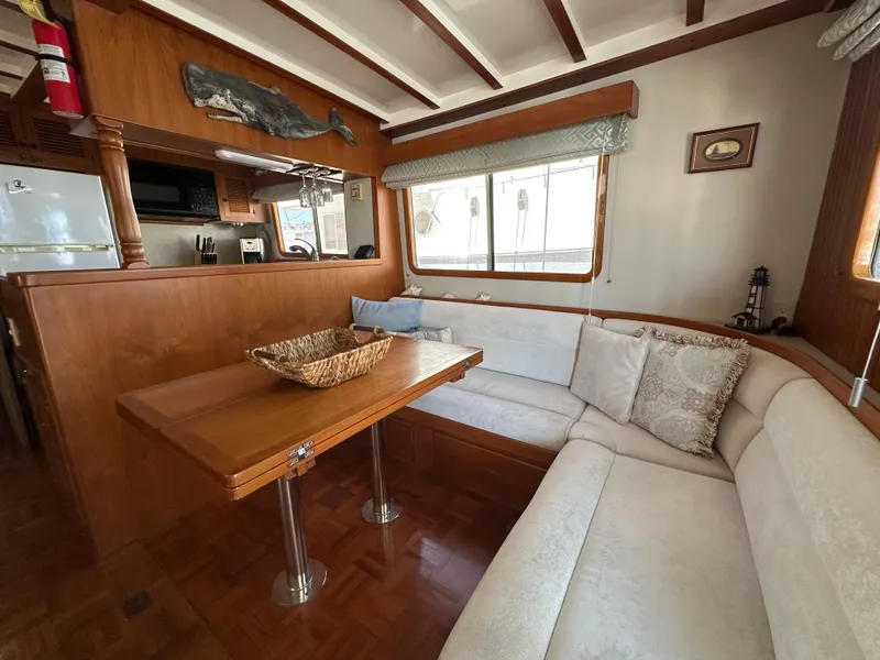 Slide: The Image of Interior of 1997 Kadey-Krogen 48 Whaleback yacht with cozy dining area and wooden accents. - 13