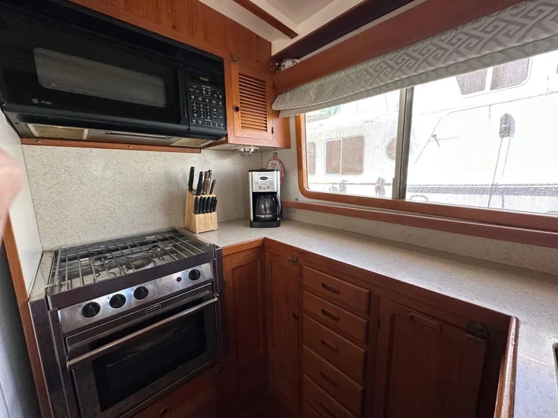 Slide: The Image of 1997 Kadey-Krogen 48 Whaleback kitchen with stove, microwave, and window view. - 15