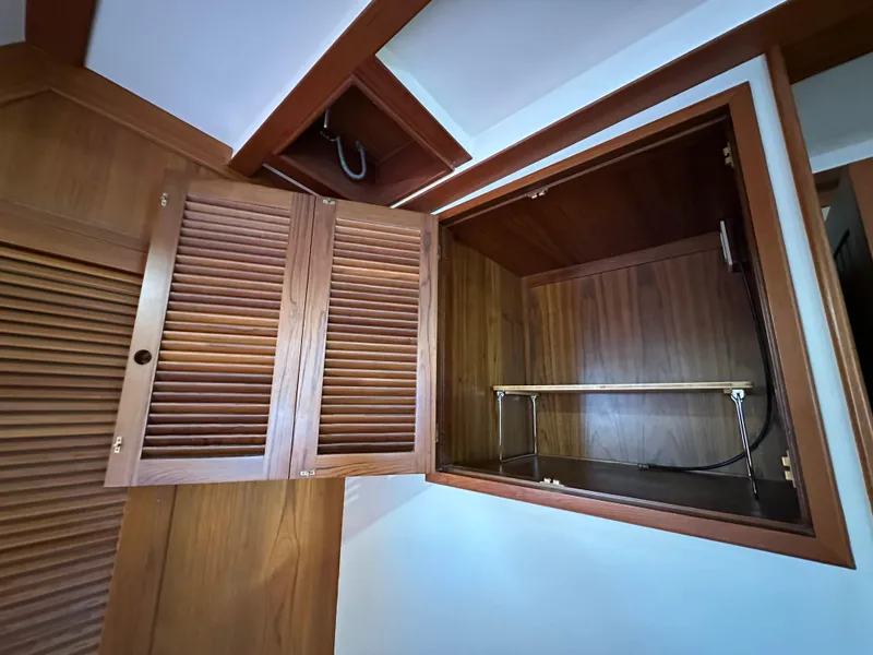 Slide: The Image of Wooden closet interior with shelves, hanging clothes, and storage baskets on a Kadey-Krogen 48 Whaleback. - 24