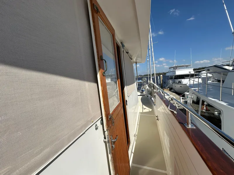 Slide: The Image of 1997 Kadey-Krogen 48 Whaleback yacht docked at marina under clear blue sky. - 50