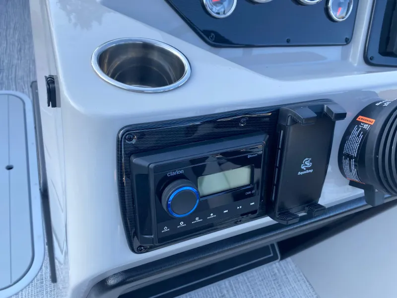 Slide: The Image of Control panel of 2025 SunCatcher Select 322RC boat with stereo and cup holder. - 17