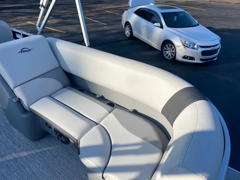 Slide: The Image of SunCatcher Select 322RC 2025 boat interior with parked white car in background. - 20