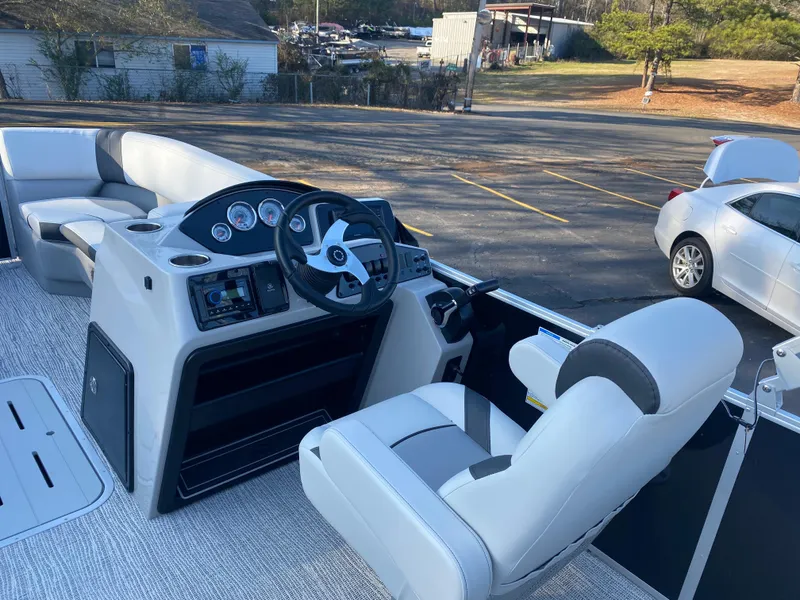 Slide: The Image of 2025 SunCatcher Select 322RC boat interior with steering console and seating. - 21