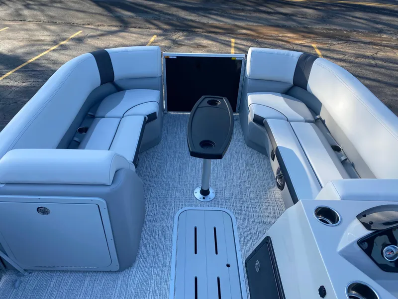 Slide: The Image of 2025 SunCatcher Select 322RC boat interior with gray seating and central table. - 7