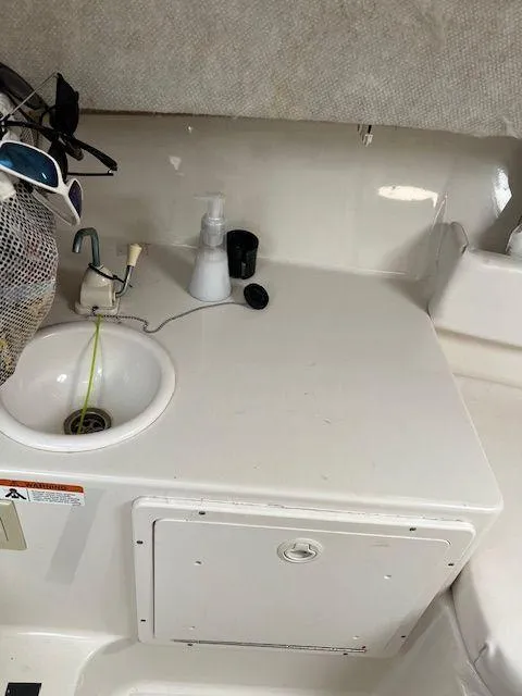 Slide: The Image of 2003 Seaswirl Striper 2601 Walkaround I/O boat interior with sink and storage compartment. - 16