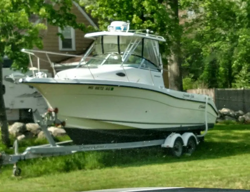 Slide: The Image of 2003 Seaswirl Striper 2601 Walkaround I/O boat on trailer, parked on grass. - 2