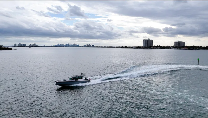 Slide: The Image of Axopar 37 XC CROSS CABIN 2023 cruising on a vast, calm waterway under a cloudy sky. - 11