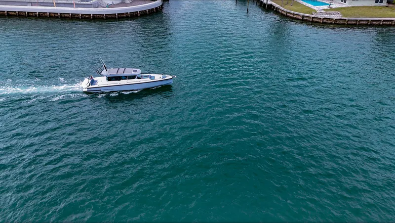 Slide: The Image of 2023 Axopar 37 XC CROSS CABIN cruising in a calm waterway. - 13