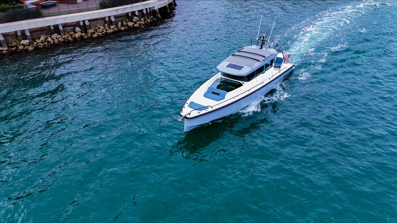 Slide: The Image of 2023 Axopar 37 XC CROSS CABIN cruising on clear blue water. - 18