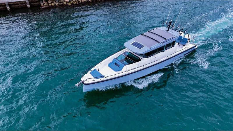 Slide: The Image of 2023 Axopar 37 XC CROSS CABIN cruising on clear blue water. - 19