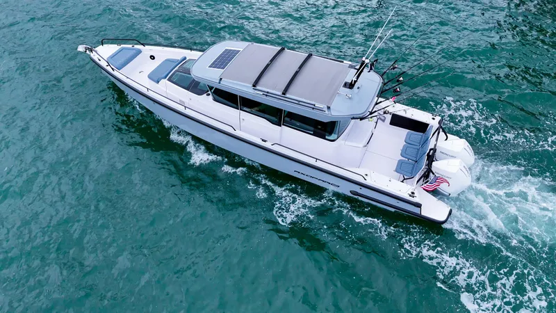 Slide: The Image of 2023 Axopar 37 XC CROSS CABIN cruising on clear blue water. - 20