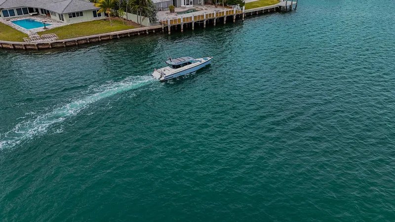 Slide: The Image of Axopar 37 XC CROSS CABIN 2023 cruising near waterfront homes. - 24