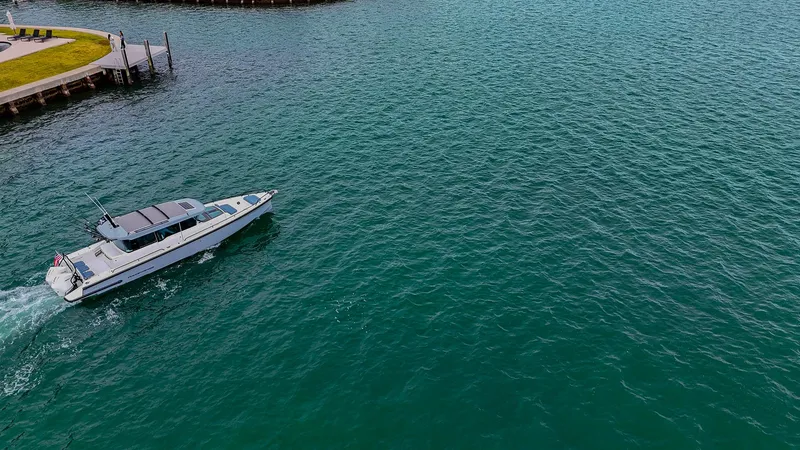 Slide: The Image of 2023 Axopar 37 XC CROSS CABIN cruising on open water near a dock. - 25