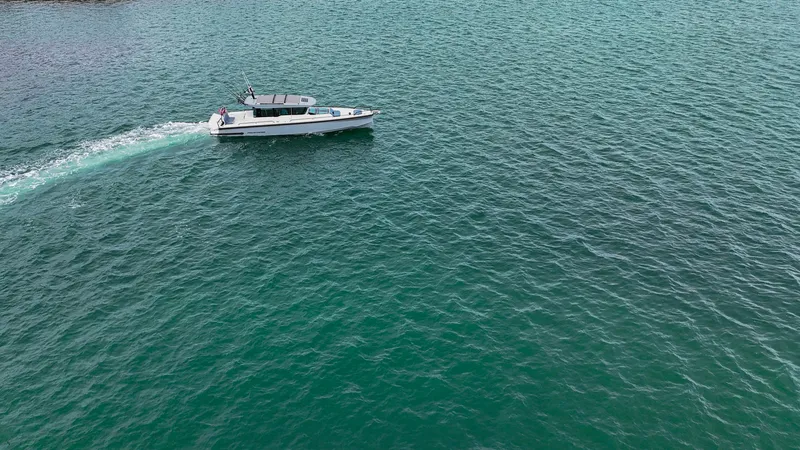 Slide: The Image of 2023 Axopar 37 XC CROSS CABIN cruising on turquoise water. - 27