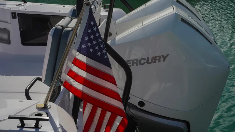 Slide: The Image of 2023 Axopar 37 XC CROSS CABIN with American flag and Mercury engine. - 30