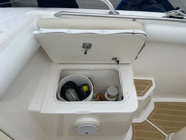 Slide: The Image of Open storage compartment on 2006 Marlago FS 35 Cuddy boat, containing various items. - 15