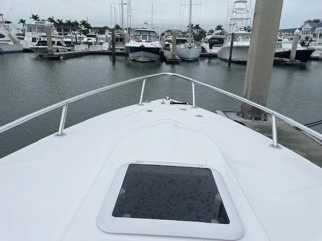 Slide: The Image of 2006 Marlago FS 35 Cuddy boat docked in a marina with other vessels. - 18