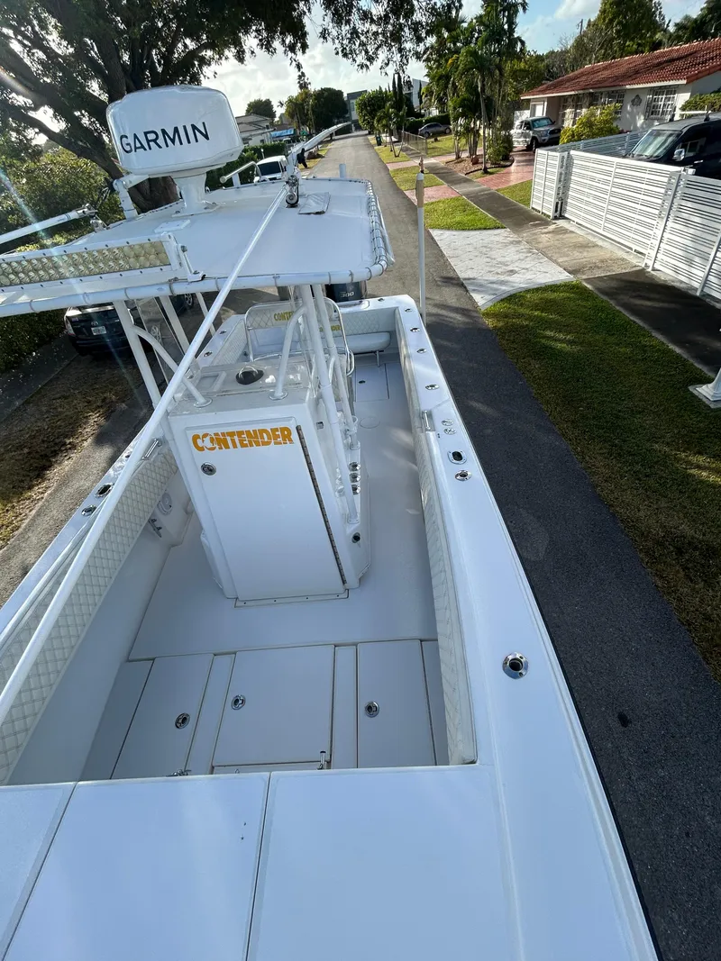Slide: The Image of 2001 Contender 27' cuddy boat with Garmin equipment, parked on a residential street. - 11