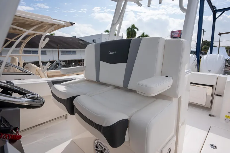 Slide: The Image of 2025 Robalo R270 Center Console boat interior with cushioned seating and steering wheel. - 11