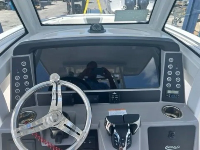 Slide: The Image of 2025 Robalo R270 Center Console boat dashboard with steering wheel and controls. - 13