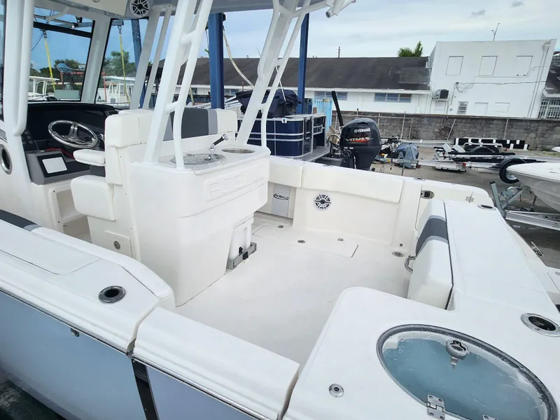 Slide: The Image of 2025 Robalo R270 Center Console boat, spacious deck, modern design, marina background. - 23