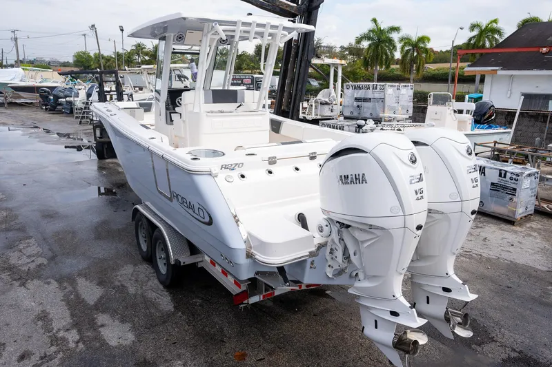 Slide: The Image of 2025 Robalo R270 Center Console boat with twin Yamaha engines on a trailer. - 28