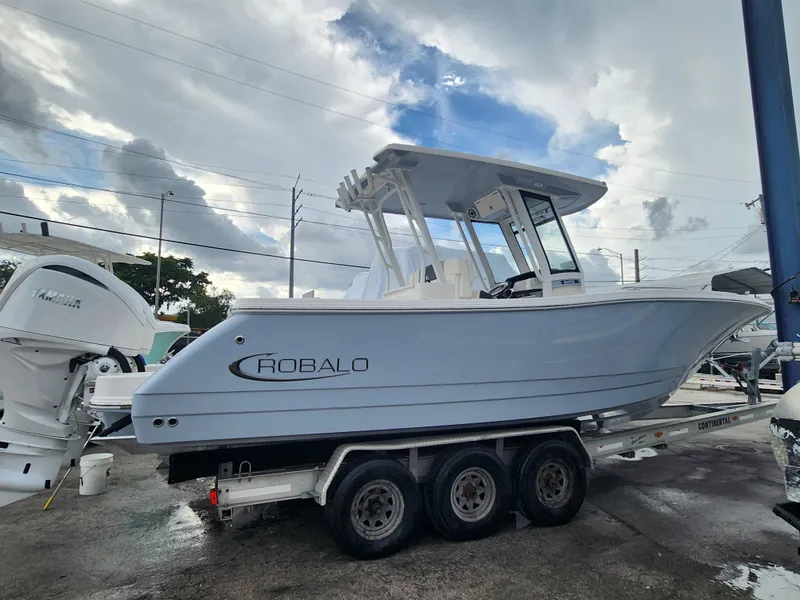 Slide: The Image of 2025 Robalo R270 Center Console boat on a trailer under cloudy sky. - 3