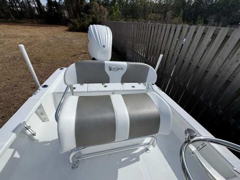 Slide: The Image of 2025 BlackJack 224 boat seat with gray and white upholstery, outdoor setting. - 12